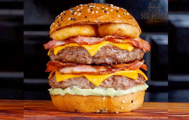 Dois hambúrgueres artesanais 160g, queijo derretido, bacon crocante em dobro, maionese especial, barbecue e anéis de cebola empanados no pão de gergelim.