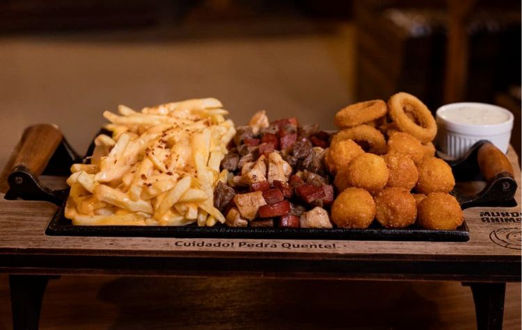 20% de Desconto na nossa Deliciosa tábua com cubos de carne, frango grelhado e calabresa, batata frita com molho 4 queijos finalizada com farofa de bacon, bolinha de queijo e anéis de cebola